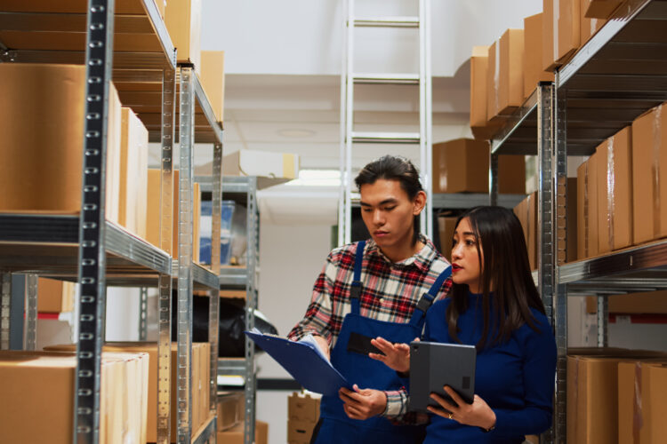 Dua orang sedang bekerja stock opname di gudang
